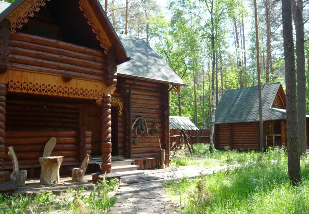 Домик с наличниками посреди деревьев. Уютные тропинки для прогулок.