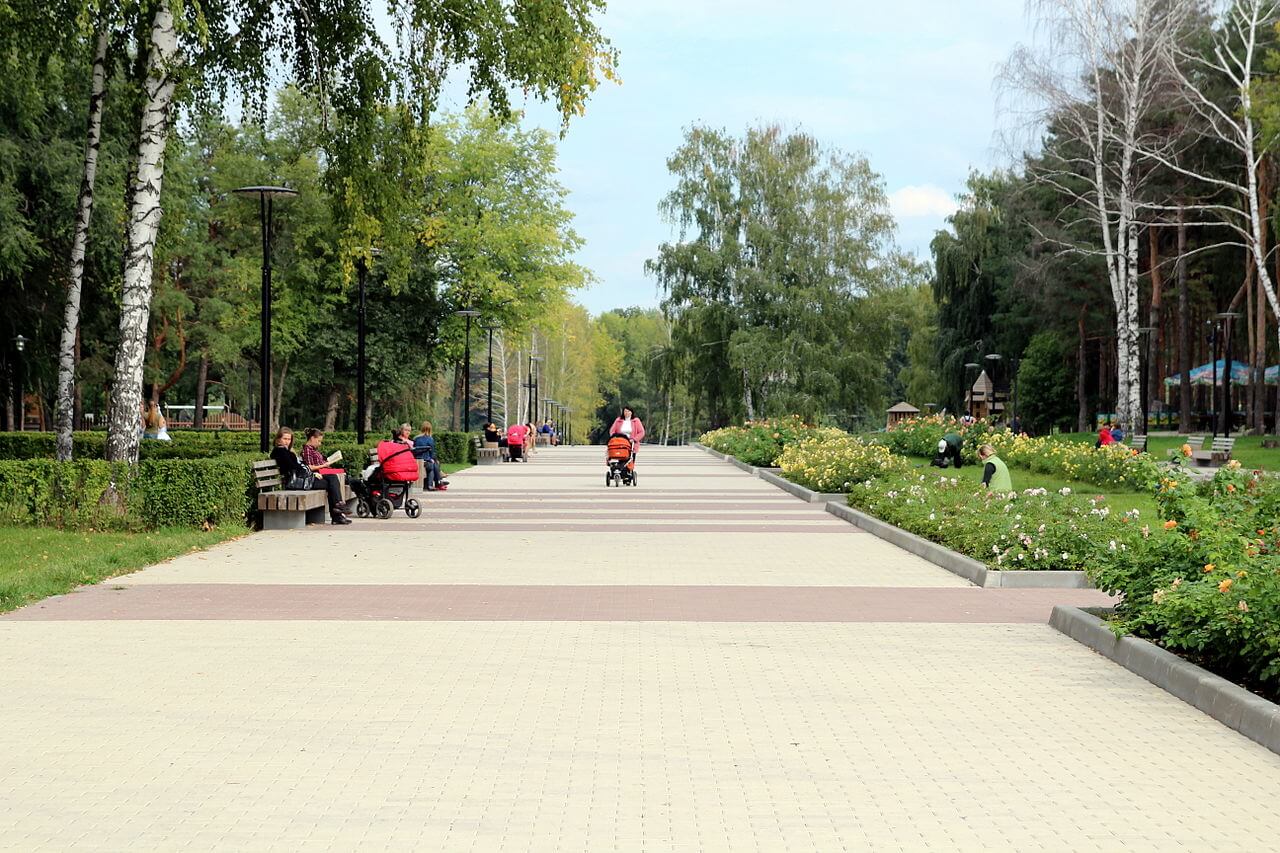 Широкая центральная аллея, цветники и лавочки.