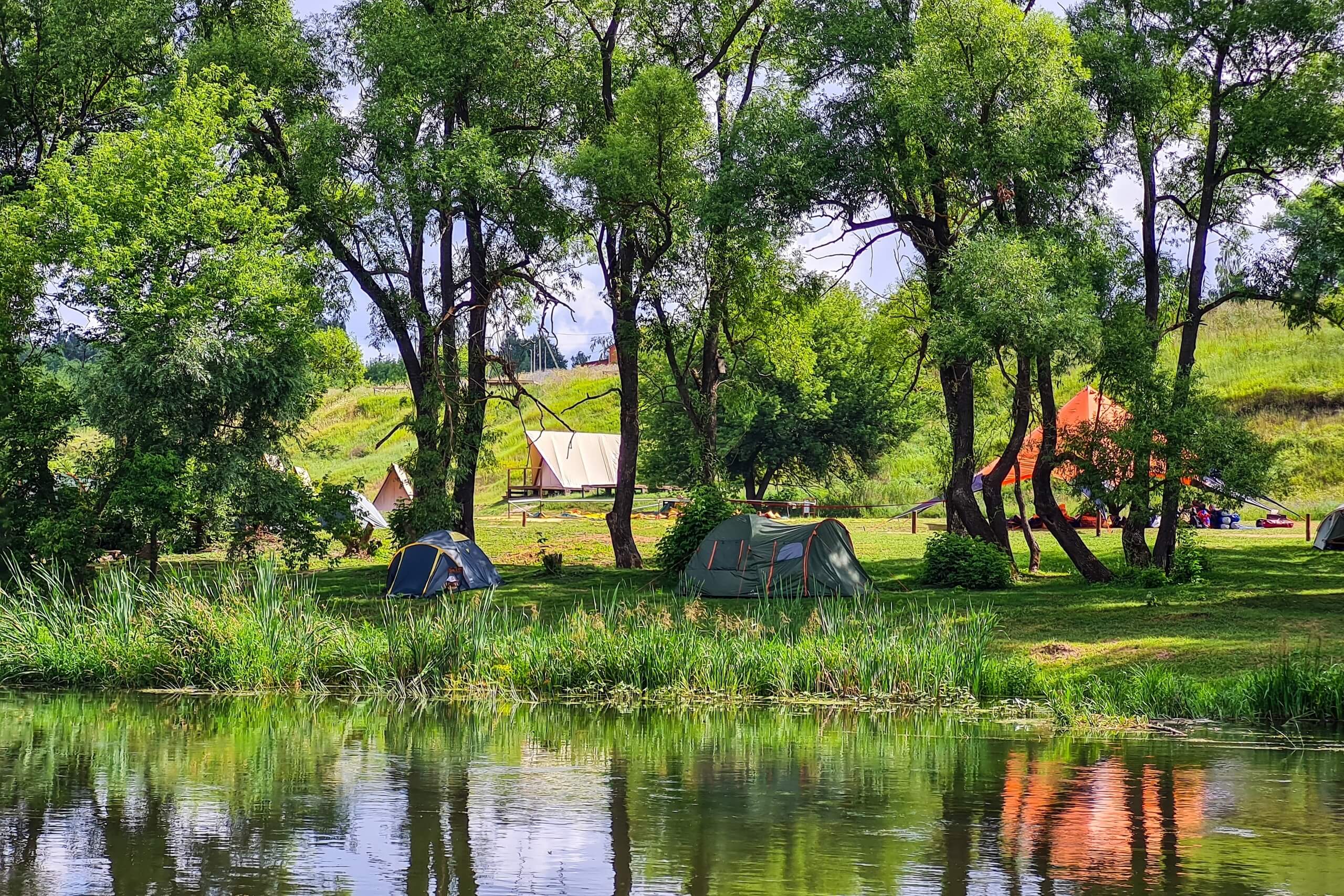 Палаточный городок на берегу пруда.