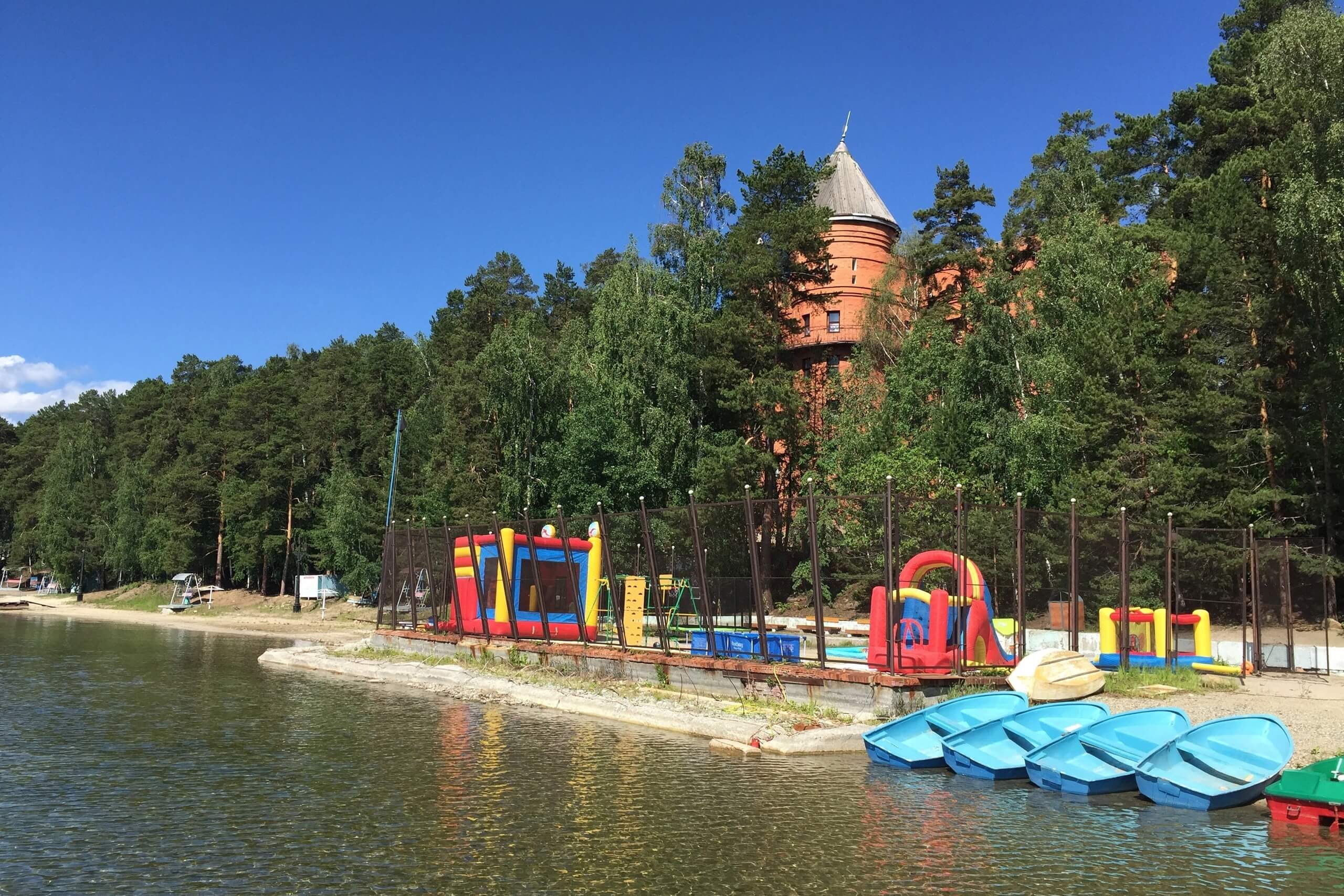 Берег озера. детская площадка, лодки.