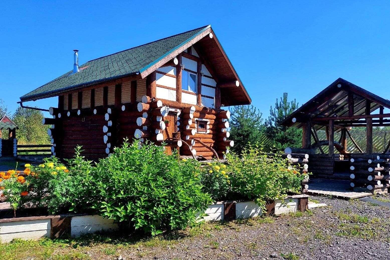 Клумба с цветами перед домом. Плодовые кустарники.