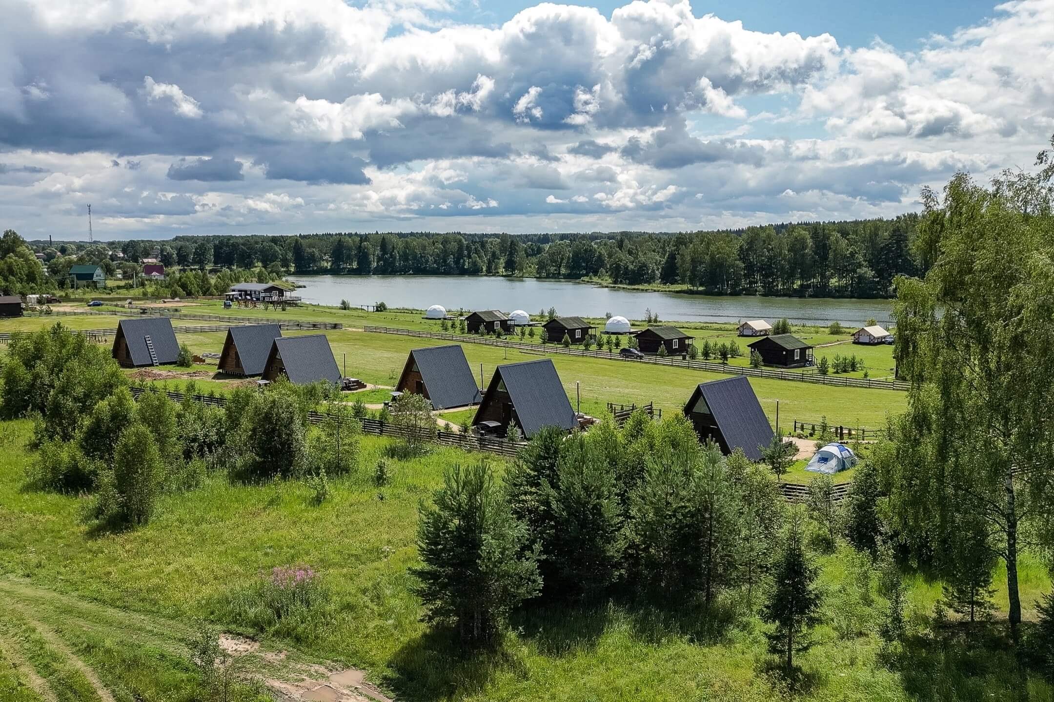 База отдыха Riverside. Панорамный вид: домики, озеро и лес.