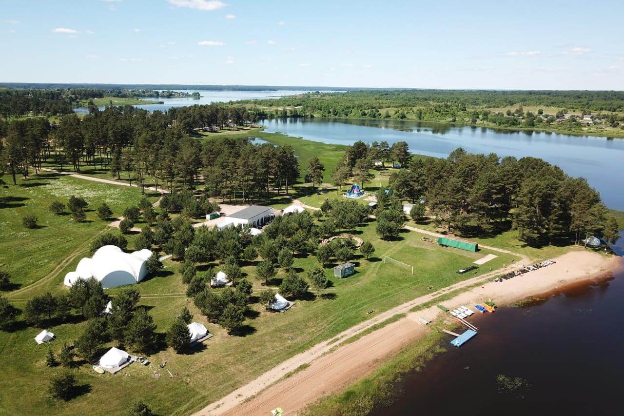 Green Glamping. Панорамный вид: река, лес и шатры-палатки.